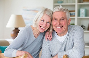 elderly couple in gray sweater smiling