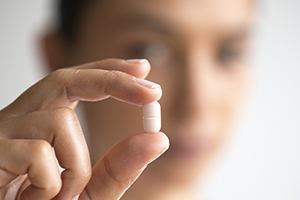 Hand holding an antibiotic pill