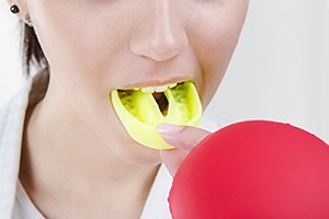 Woman taking out neon yellow mouthguard